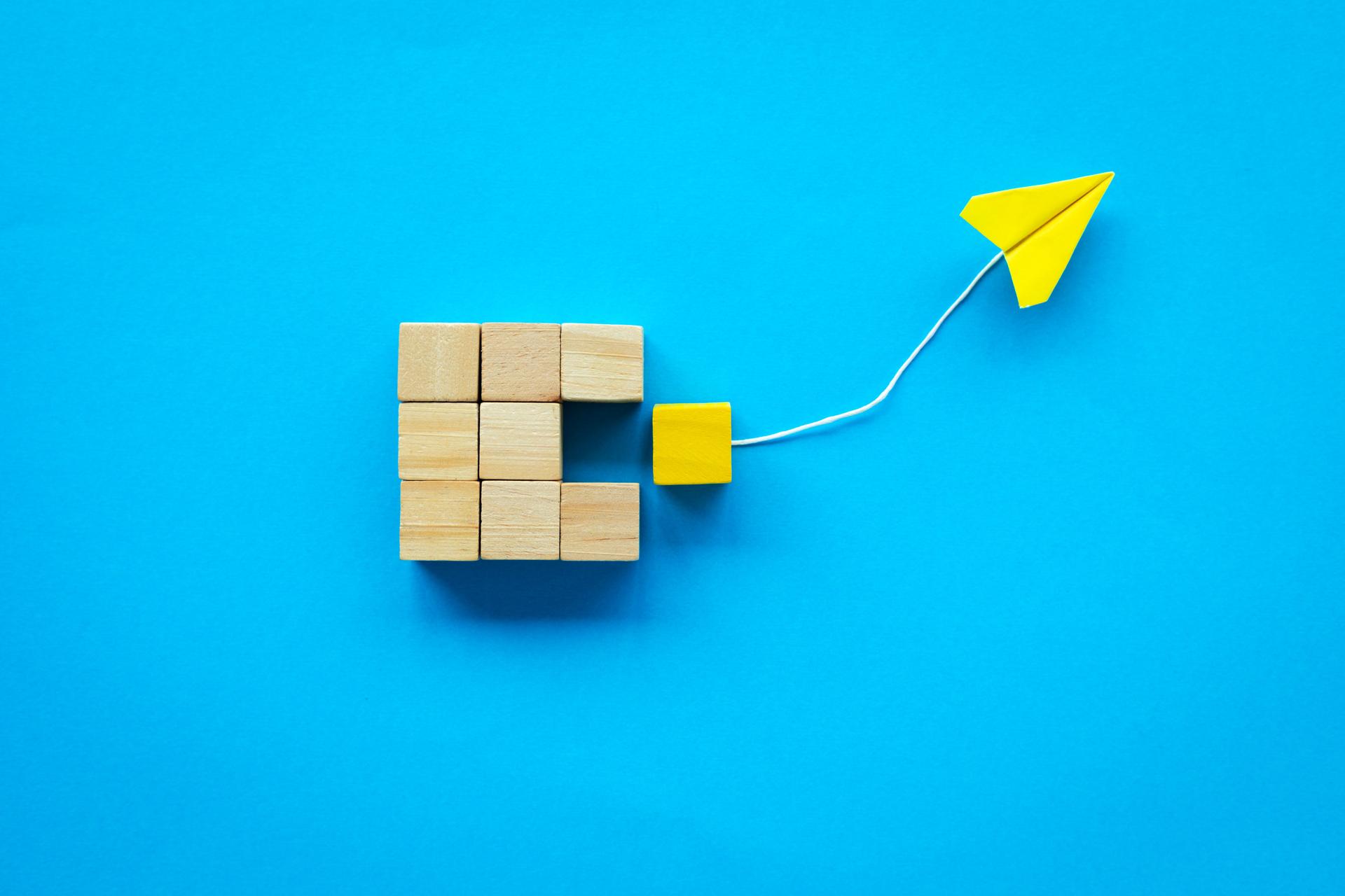 Leadership and Innovation Concept with Wooden Blocks and Paper Plane